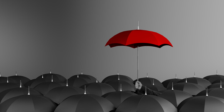 Parapluie rouge se démarquant des autres parapluies noirs